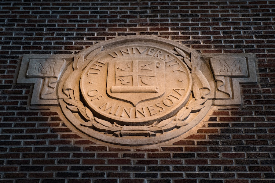 The seal of the University of Minnesota in relief on a brick wall