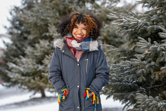 Hilaria Ponce standing outisde next to pine trees with snow on them