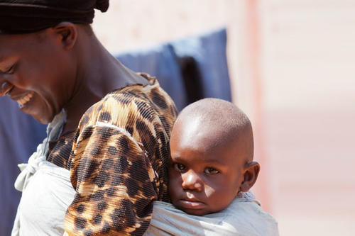 A Ugandan woman with her young child on her back