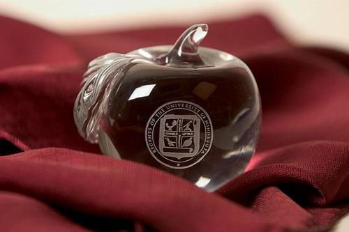 A glass apple with the regents seal on it
