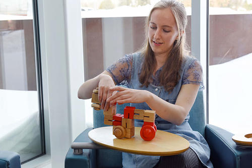 Micki Grover playing with wooden toys she designed