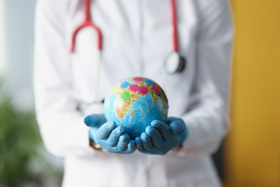 Doctor holding a globe in gloved hands.