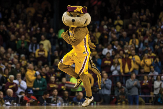 Goldy skipping on the court wearing basketball uniform