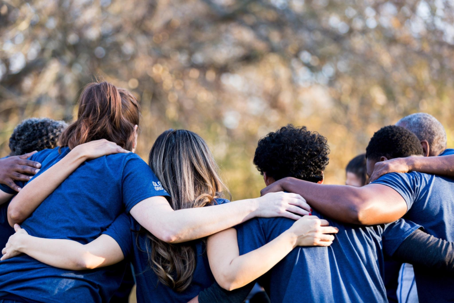 A group of diverse young people linking arms