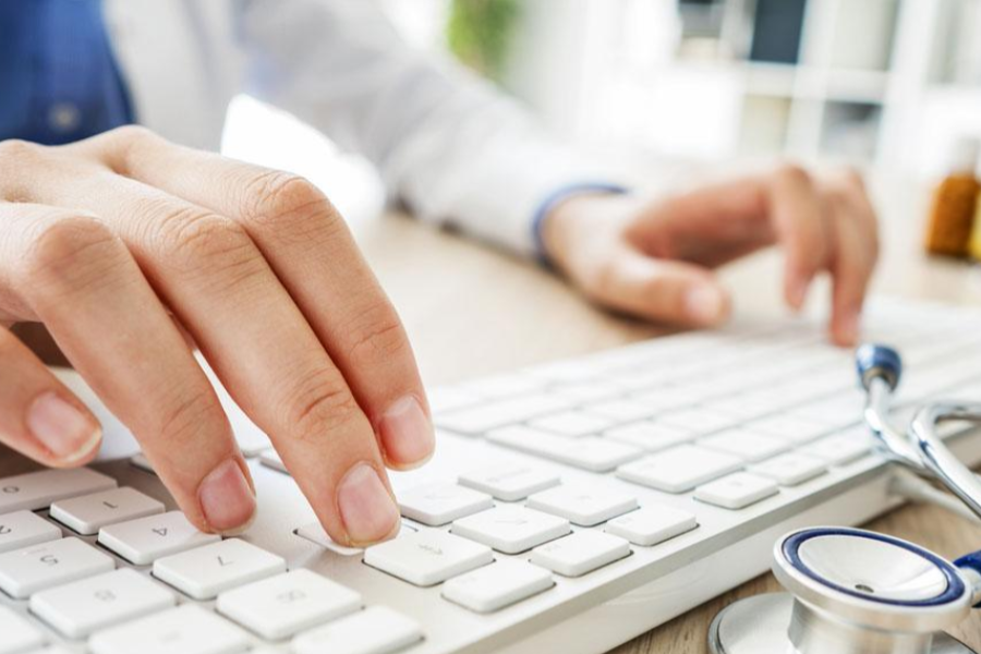 Healthcare provider typing on a keyboard