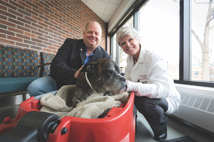 Liz Pluhar and Michael Olin pose with a canine patient named Gidget. Photo by Brady Willette.