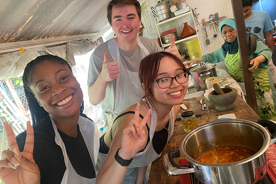 Three students pose with their laksa. 