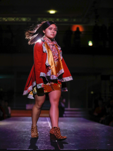 Model makes the turn at the end of the runway, wearing bright red jacket