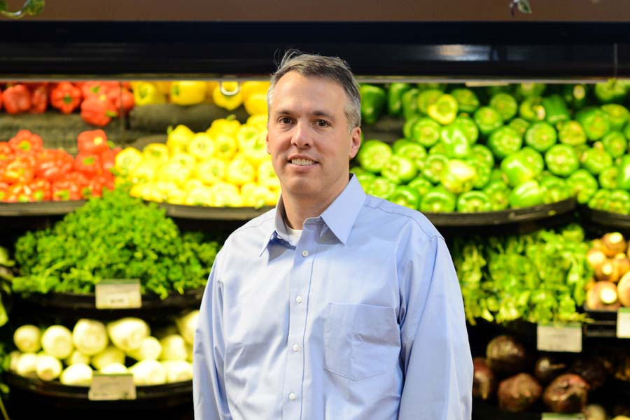 Professor Joe Redden in the produce section of a grocery store.