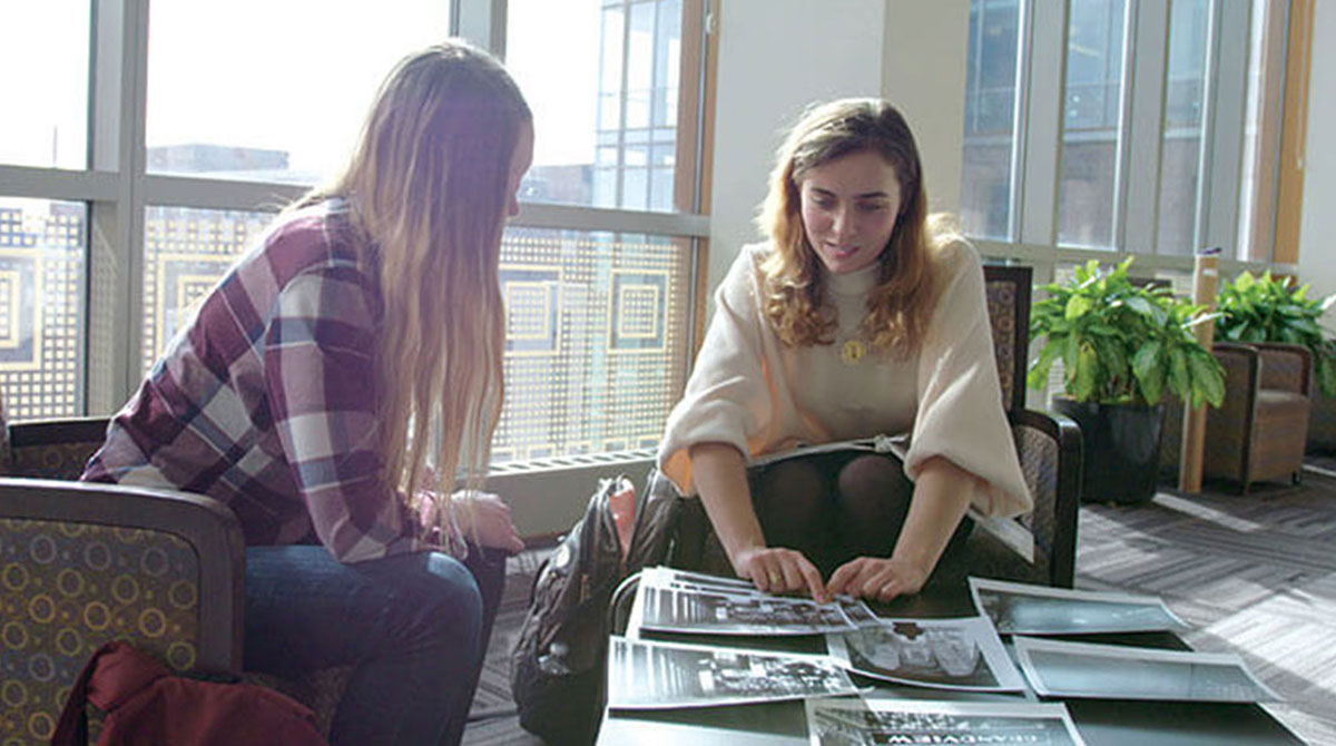 students looking at pictures on a table