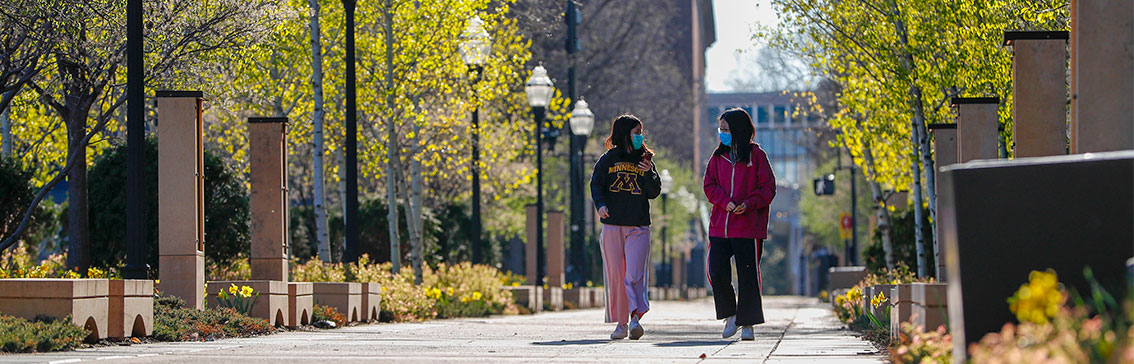 Students walking on campus wearing masks