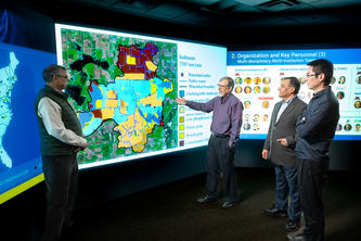 Researchers standing in front of an interactive map