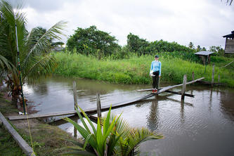 Lexi Frank in South America on a small footbridge over water