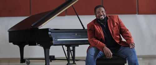 Adrian Davis posing with grand piano