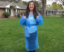 student in Grown Up for U program standing in their front lawn wearing home-made PPE giving thumbs-up to the camera
