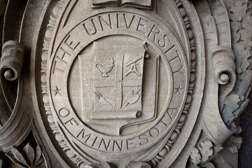 The seal of the University of Minnesota Board of Regents appears carved in off-white stone