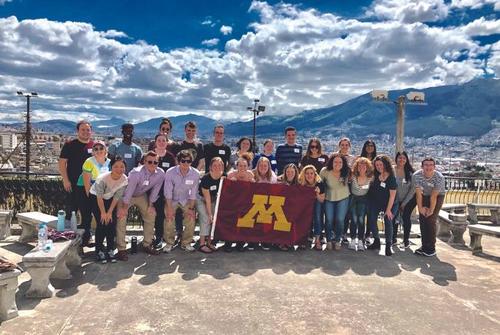 Students posing with University of Minnesota flag in Ecuador