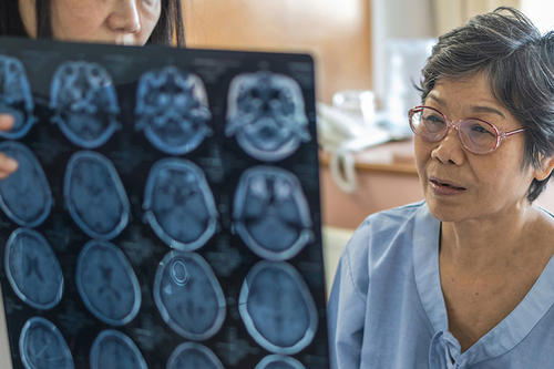 A doctor shows scans to a woman patient.