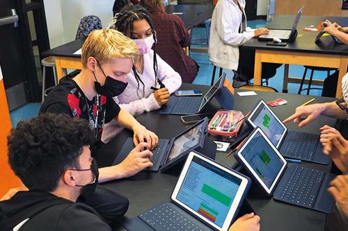 Students with laptops in a classroom setting