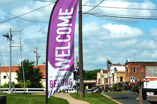 A Welcome sign in front of a small town's Main Street.