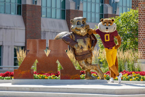 Goldy posing with Goldy statue in front of Coffman Union