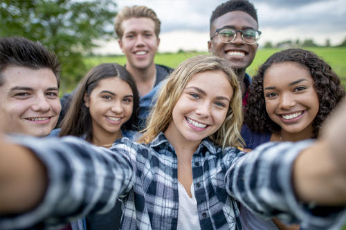 A group of six young adults looking into the camera, apparently taking a selfie