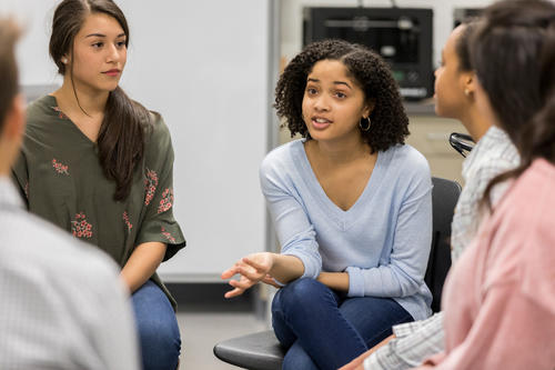 Young women sitting in a circle and talking