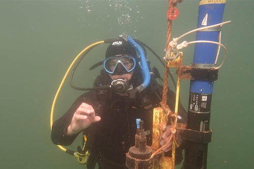 Photo of diver collecting data at a buoy in Lake Superior.