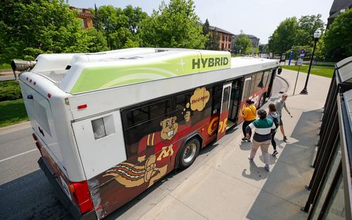 student getting onto hybrid bus on Pleasant Ave