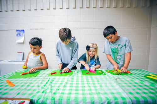 Children at a Taste Buds event get hands-on experience slicing and dicing ingredients for a stir-fry.