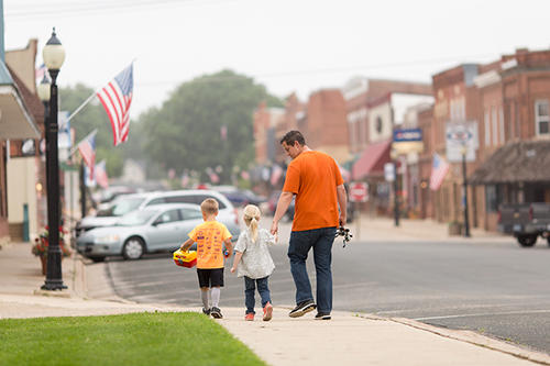 A family walks on a sidewalk in Spring Valley, Minnesota.