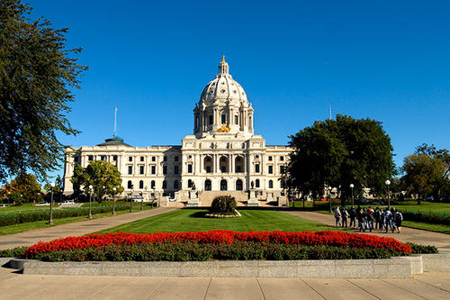 A group of people walks toward the Minnesota State Capitol.
