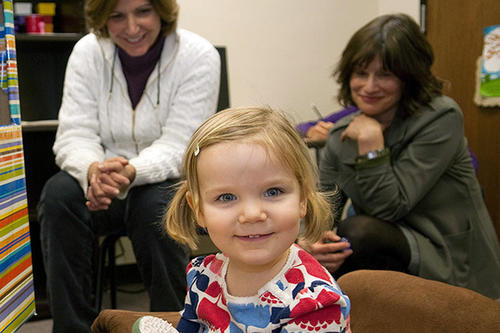 A smiling child with researchers