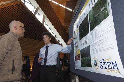 A student describes his research at a poster session