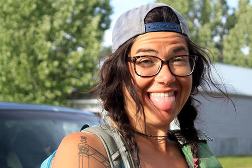 Alexandera Houchin, in glasses and backward cap, with big grin and sticking out her tongue..