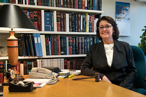 Ann M. Burkhart, with bookshelf in background.