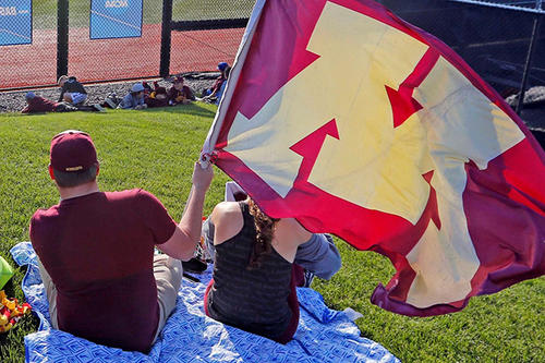 Fans at a baseball game wave an &quot;M&quot; flag.