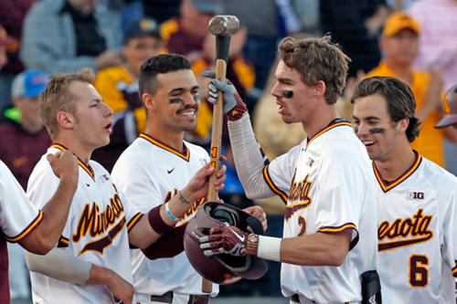 Gopher players celebrate with a trophy after beating UCLA in the Minneapolis Regional championship game.