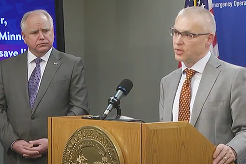 Gov. Tim Walz listens as Jakub Tolar, at the lectern, speaks at the news conference.