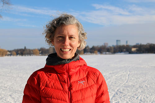 Jennifer Ringold standing in front of a Minneapolis lake and the city&#039;s skyline