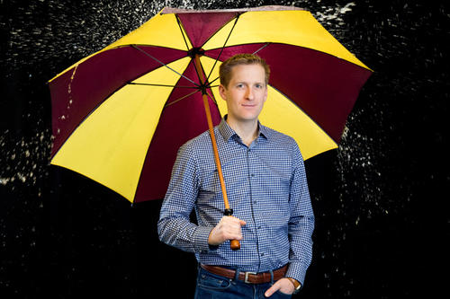 Joshua Madsen holding an umbrella.