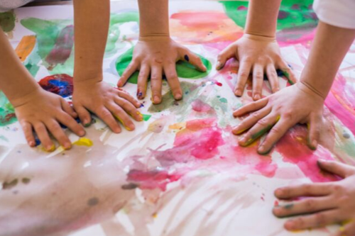 Kids playing with hand paint.