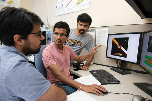 Mrubank Bhatt and two other grad students discuss matters.