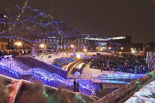 Panoramic view of a previous show, with a crowd and blue streams of light.