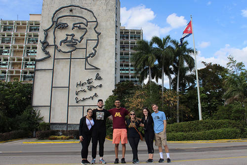 Students pose outside an iconic building in Cuba.