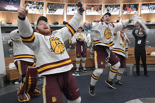 UMD hockey players celebrate in the locker room.