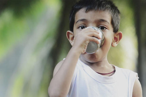 Young boy drinking water.