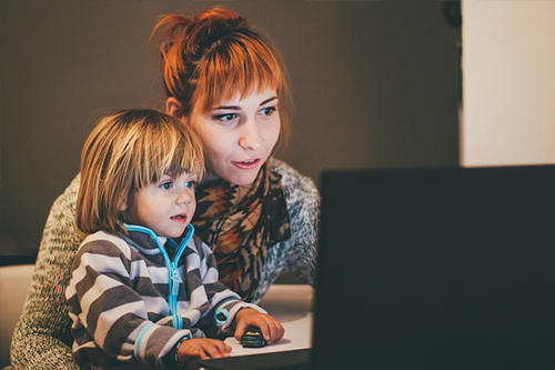 a mother and child at a computer
