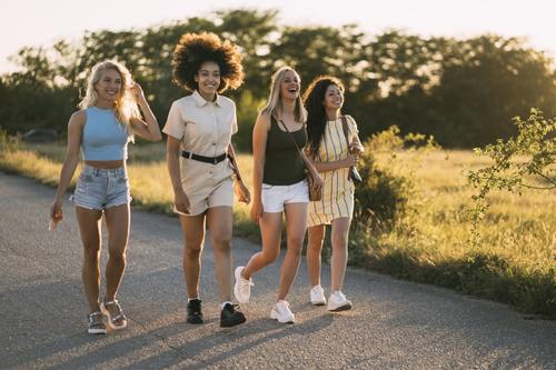 four young women walking outside